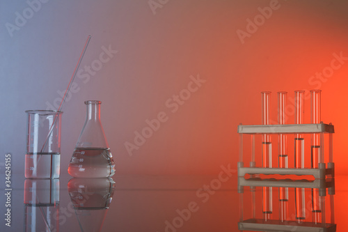 conceptual background with chemical flasks and lab glassware. lab glassware on glass table with copy space.