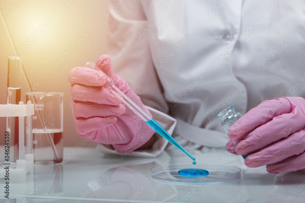 Biochemist`s hands in gloves are conducting chemical experiments in lab. chemist works with lab glassware close up Biochemist`s hands in gloves are conducting chemical experiments in lab. chemist works with lab glassware close up