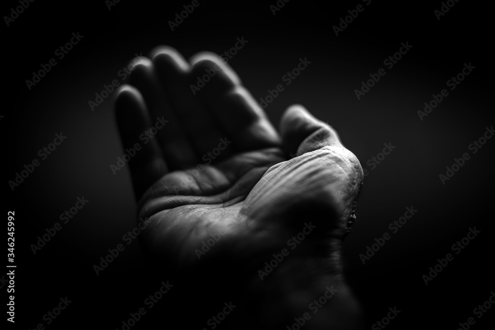 Black and white. Wrinkled right hand on a black background Black and white. Wrinkled right hand on a black background