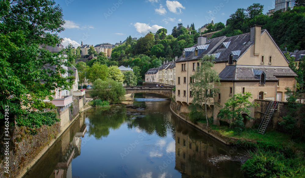 View from the bridge to the river and the old city of Luxembourg on a sunny day.