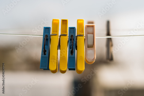 Two colorful clothespin white and yellow on the white rope