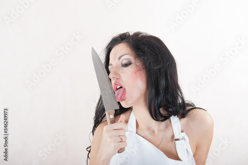 girl licks a knife. Brunette with a big knife