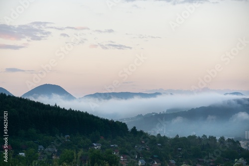 Sunrise and sunset, beautiful clouds over the meadow, hills and buildings in the town. Slovakia