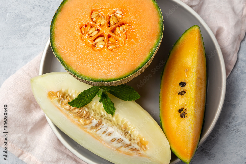 Fresh assortment melon with mint on gray Fresh assortment melon with mint on gray