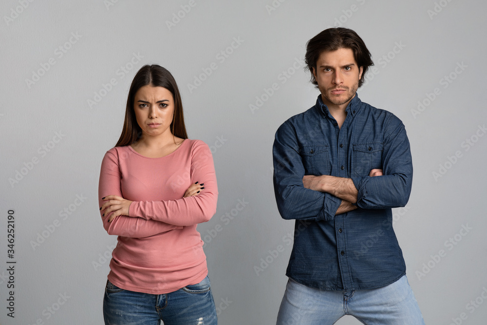 Millennial couple suffering from relationship problems, standing together offended after quarrel Millennial couple suffering from relationship problems, standing together offended after quarrel