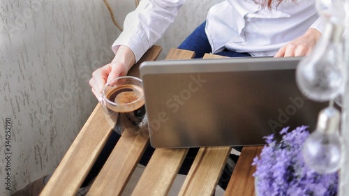 Close up of woman working on a laptop on balcony during corona virus quarantine