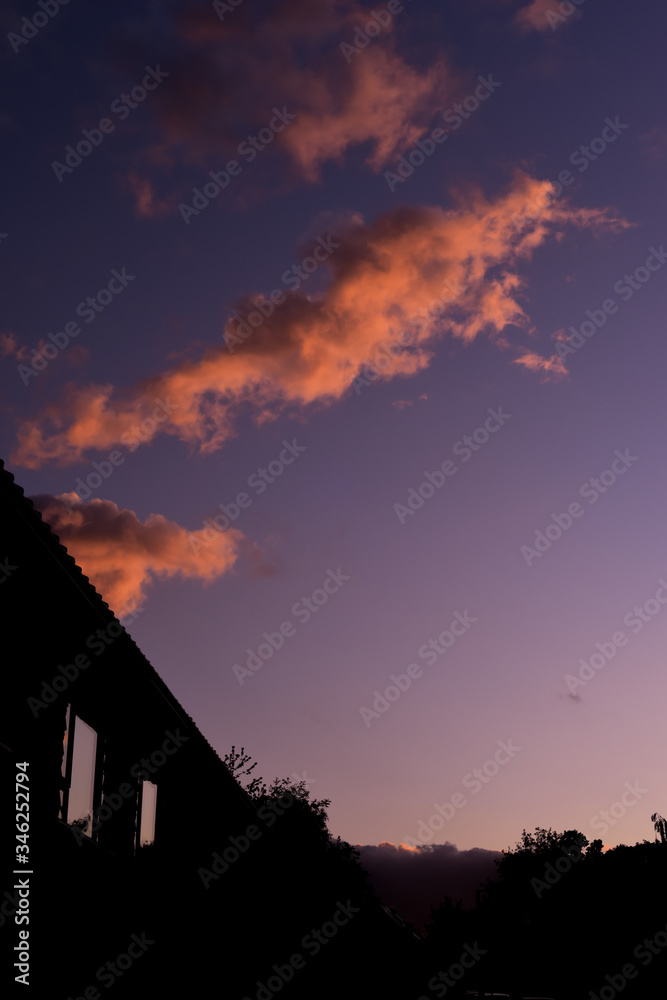 Fototapeta premium Houses on a suburban street silhouetted in evening sky