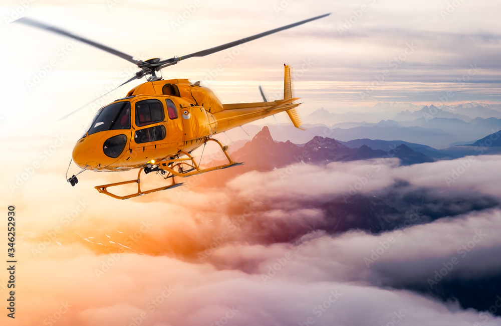 Yellow Helicopter flying over the Rocky Mountains during a sunny sunset. Aerial Landscape from British Columbia, Canada near Vancouver. Composite Yellow Helicopter flying over the Rocky Mountains during a sunny sunset. Aerial Landscape from British Columbia, Canada near Vancouver. Composite
