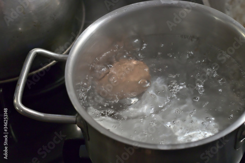 One egg boiling in a pot