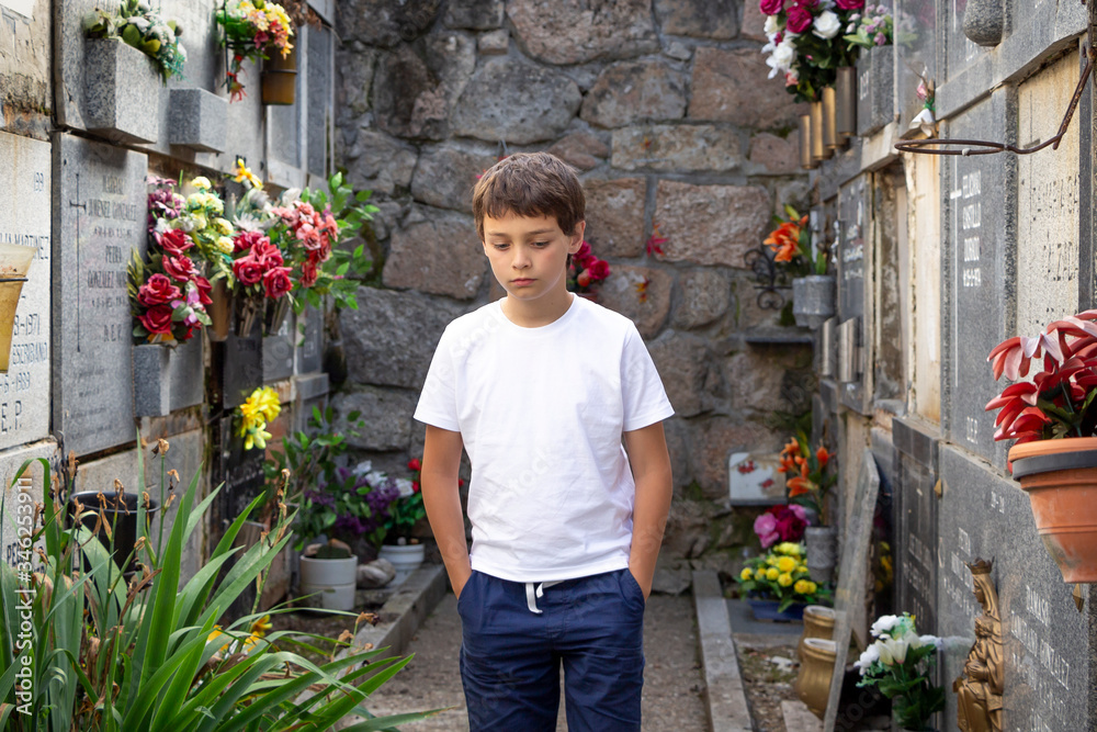 BOY WALKING IN NICHE CORRIDOR IN CEMENTERY BOY WALKING IN NICHE CORRIDOR IN CEMENTERY