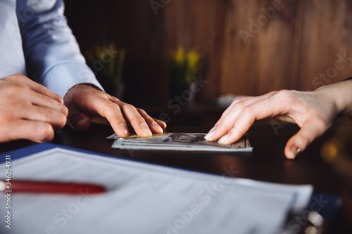 Foto Close-up Of Judge Hands Counting Banknote In Front Of Gavel At Desk