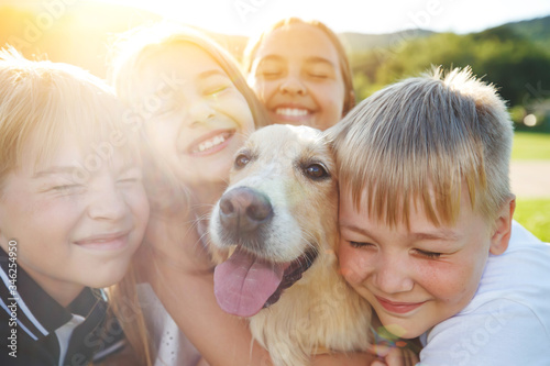 Children play with a dog in nature. A group of children in the street with a cradle. © nuzza11