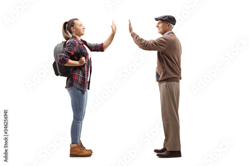 Female student greeting an elderly man with a high-five