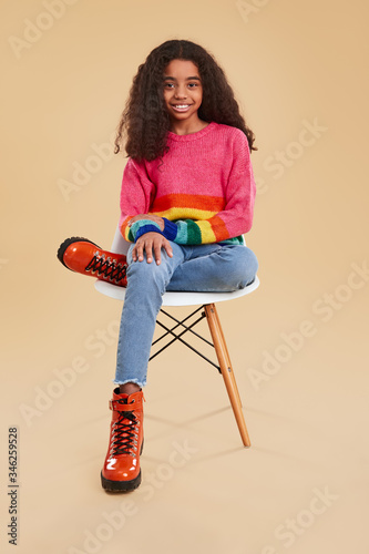 Stylish black child sitting on chair