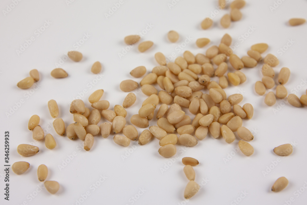 A handful of pine nuts on a white background. Healthy lifestyle. The ingredients for the dishes. A handful of pine nuts on a white background. Healthy lifestyle. The ingredients for the dishes.