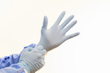 Doctor putting on medical gloves isolated on white background.