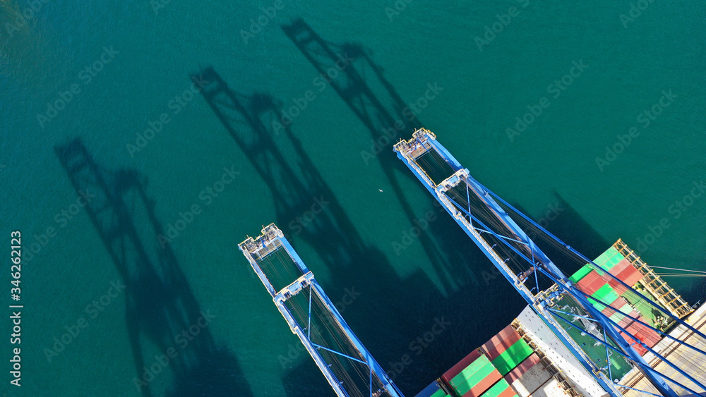 Aerial drone photo of loading/unloading by using cranes to tanker ships in logistics container terminal in Mediterranean port
