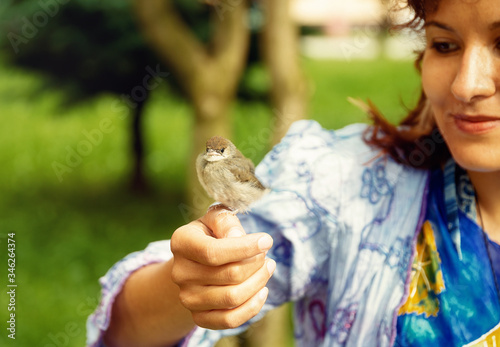 woman with a small bird. bird in hand.
