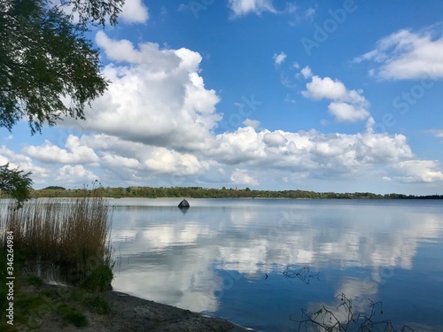 Der weiße Stein vom Noor Eckernförde mit Wolken und Spiegelung im See