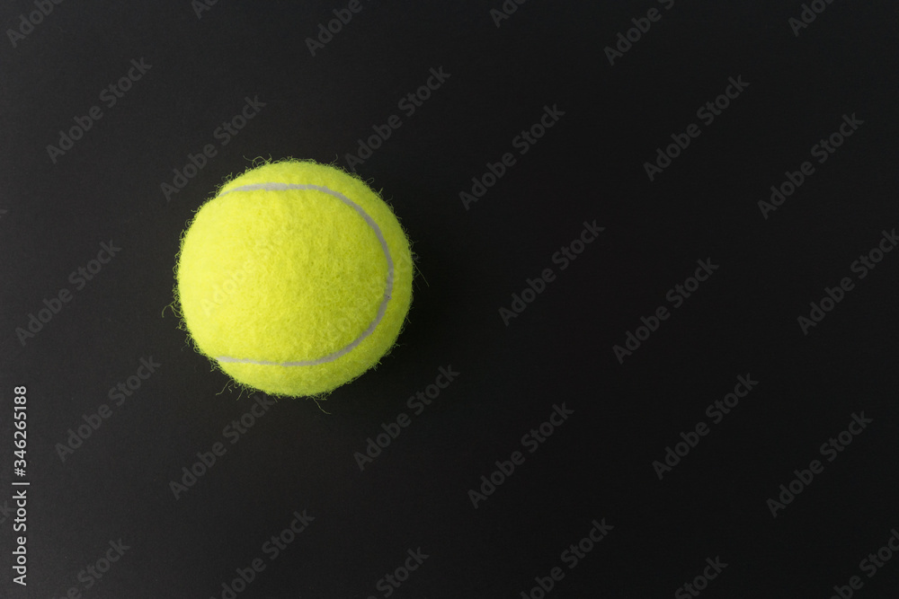 close up image of yellow tennis ball on black background, space for text, sport activities