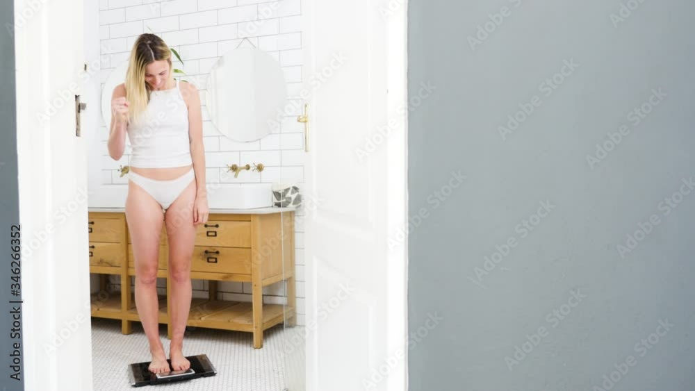 Woman on the scale happy with her weight loss result Woman on the scale happy with her weight loss result
