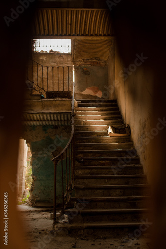 escaleras de un lugar abandonado con un rayo de luz entrando por una ventana 
