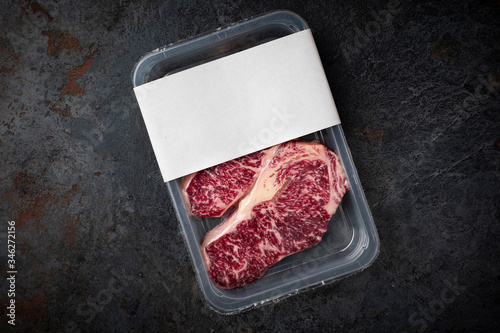 Fotografi Raw Wagyu marbled beef steak in vacuum packaging, logo mockup for design