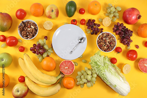 Fototapeta Naklejka Na Ścianę i Meble -  Tropical fruits, grapefruit, orange, granola, lemon on a yellow background, healthy food, summer banner. The concept of minimal relaxation, detox diet. Place for text, flat lay.