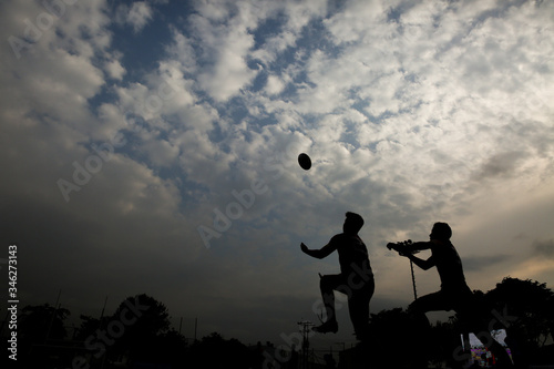 Silhouette of a man with a rugby ball