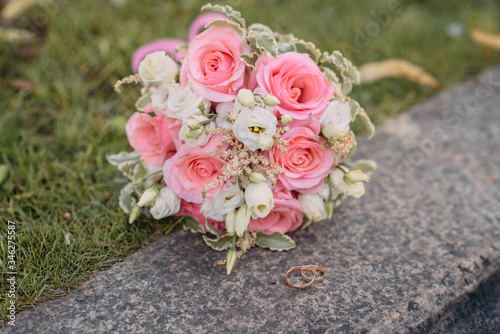A bouquet of white and pink roses lies on the ground