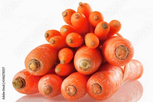 Stack of fresh carrots against white background.