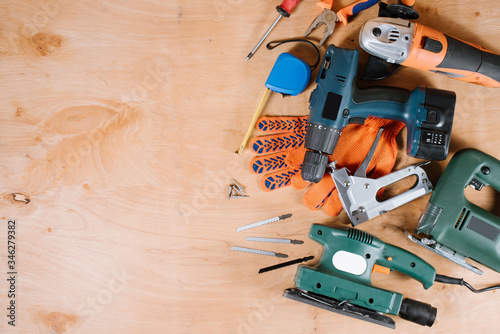 Electric building and crafting instruments and tools on the wooden background