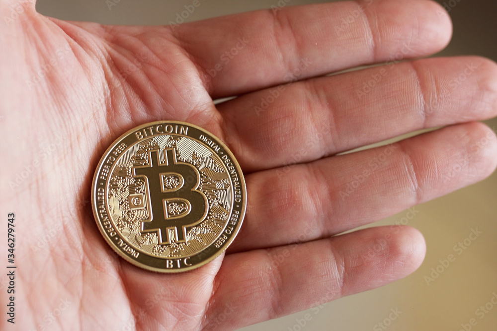Man Holding Bitcoin In His Hand. Bitcoin Shows On Screen. Close Up shot Man Holding Bitcoin In His Hand. Bitcoin Shows On Screen. Close Up shot
