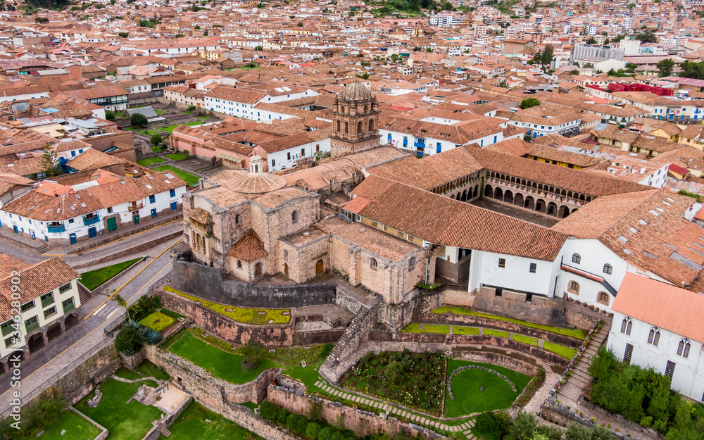 Aerial side view over empty Qorikancha gardens, Inca temple of the Sun in Cusco, and the empty streets of the city because of Coronavirus