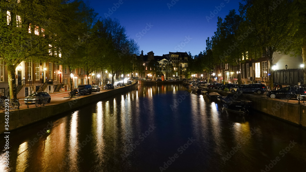 Night view of buildings along a canal in Amsterdam.