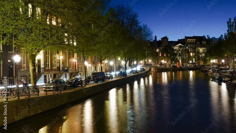 Night view of buildings along a canal in Amsterdam.