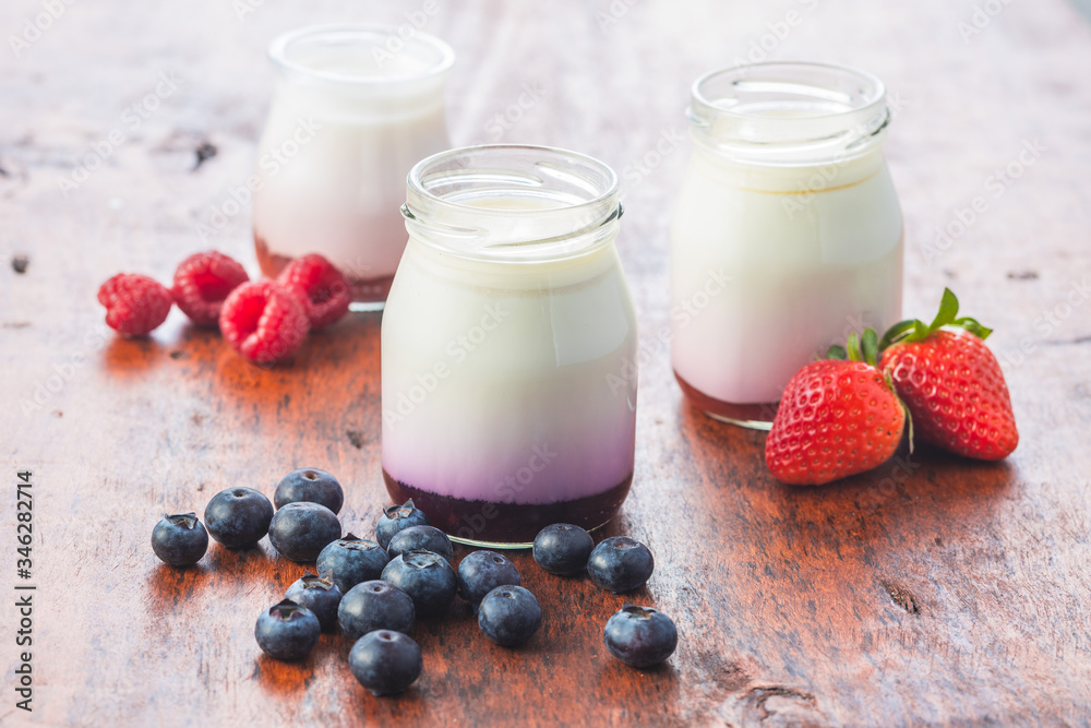 White fruity yogurt in jar and blueberry, raspberry, strawberry White fruity yogurt in jar and blueberry, raspberry, strawberry