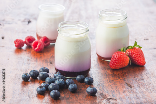 White fruity yogurt in jar and blueberry, raspberry, strawberry