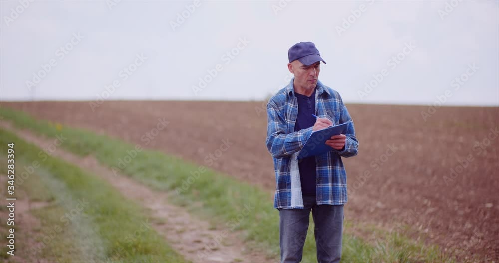 Thoughtful Male Botanist Writing On Clipboard Thoughtful Male Botanist Writing On Clipboard