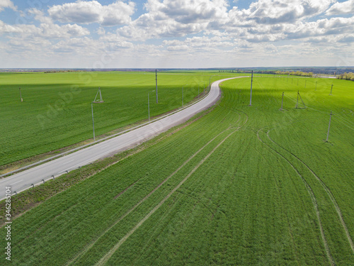 Aerial drone photo. Road among the green fields.