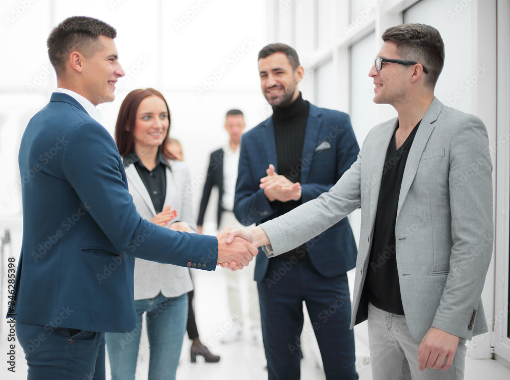 business partners shaking hands standing in the office business partners shaking hands standing in the office