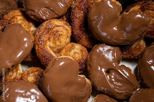Palmier biscuits covered of chocolate. Top view close-up. Heart-shaped puff pastry, pig's ear, palm leaves cookies, elephant ears, french hearts, shoe-soles.
