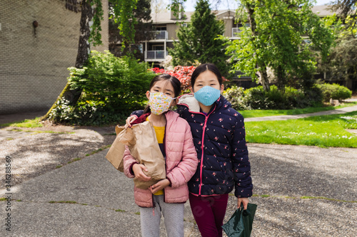 Portrait of siblings wearing mask standing outdoors