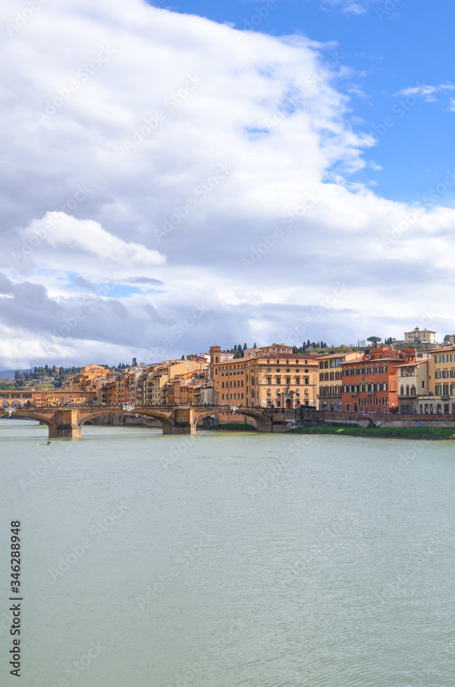 Cityscape of Florence, Tuscany, Italy. Historical center located along the Arno river. Blue sky and clouds over the Italian city. Vertical photo.