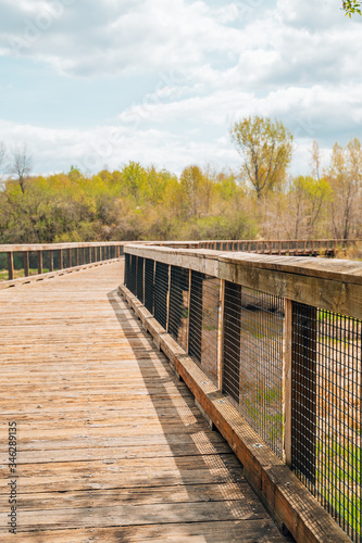Lovely spring day in Elm Creek Park Reserve in Maple Grove, Minnesota. Wooden pedestrian footbring, portrait view, on the trails