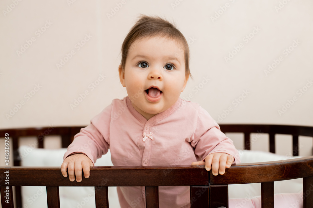 Portrait of a toddler girl sitting at home in a cot in her pajamas Portrait of a toddler girl sitting at home in a cot in her pajamas