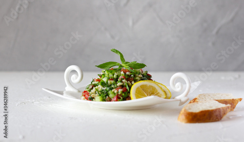 Tabbouleh salad and bread. Vegetarian salad with bulgur wheat, chopped tomato, cucumber, parsley and mint. Lebanese and Middle Eastern cuisine. Copy space