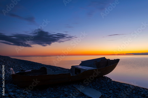 Damage boat on an cobblestone beach during sunset, Sweden