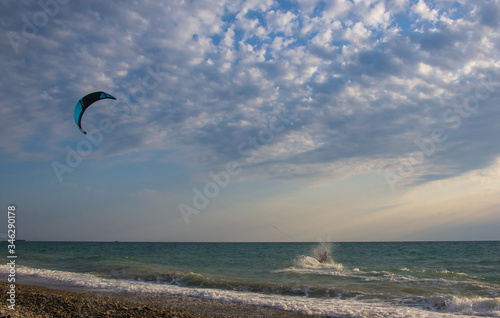 kitesurfer rides a kite-surf on waves of the sea