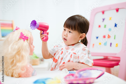 Canvas Print toddler girl pretend play as hairdresser  at home